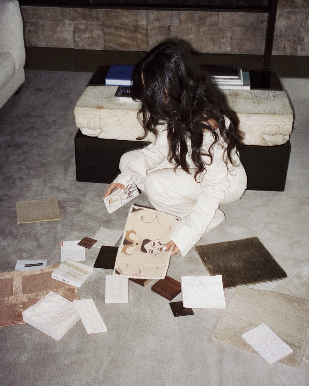 Interior designer reviewing material and fabric samples on the studio floor